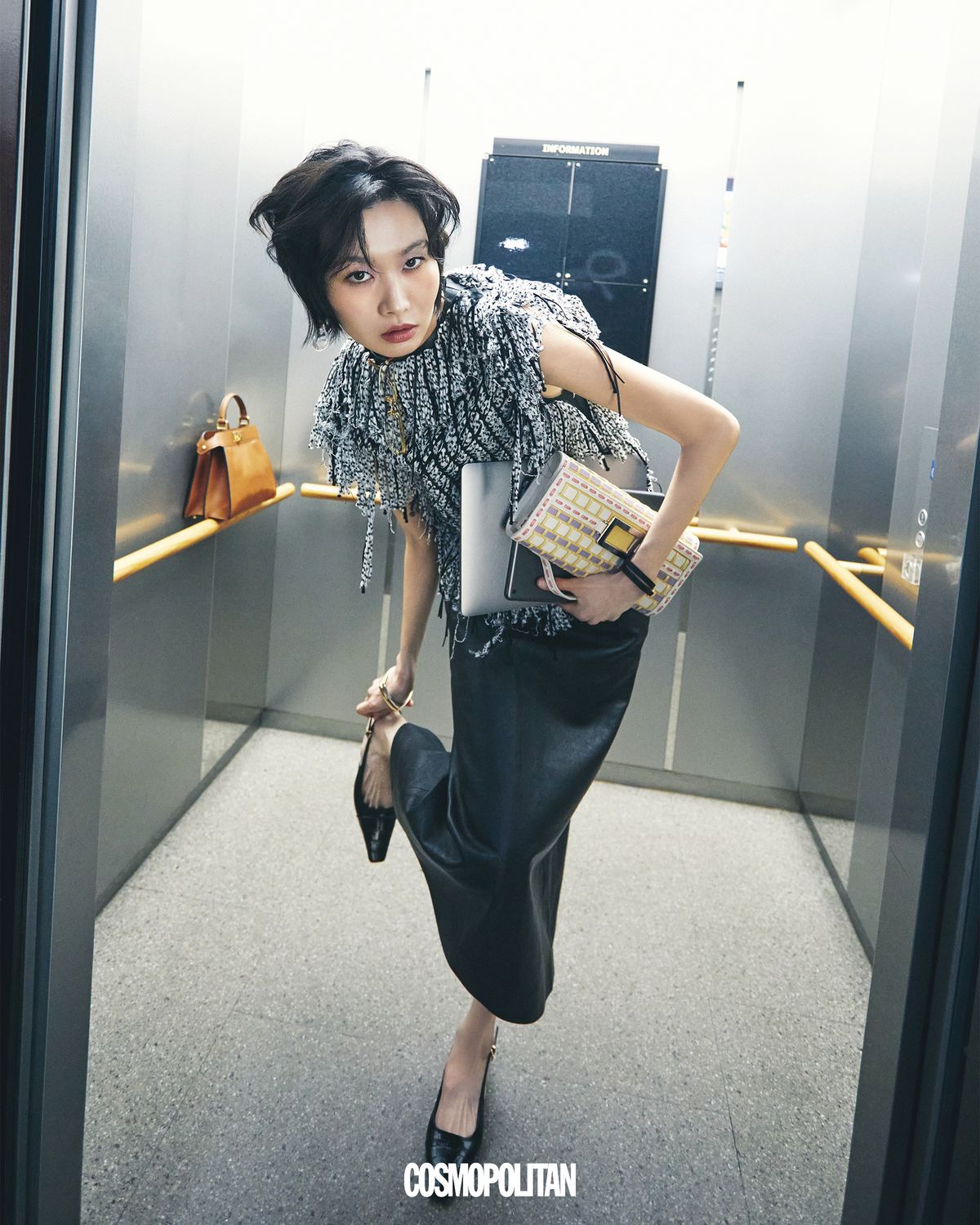 레더 프린지 톱 가격미정, 펜슬 스커트 5백25만원, 슬링백 1백36만원 모두 Tod’s. 귀고리 39만3천원 Polène. 오른팔에 레이어드한 골드 뱅글 1백79만원, 실버 뱅글 1백53만8천원 모두 Tom Wood. 왼팔의 가죽 뱅글 가격미정 Hermès. 톱에 걸린 안경 91만원 Louis Vuitton. 컬러 블록 토트백 가격미정 Roger Vivier. 엘리베이터 손잡이에 놓인 피카부 백 1천만원대 Fendi.