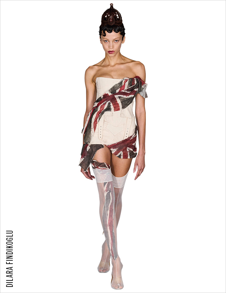 유니온 잭 프린트의 드레스와 왕관을 쓴 모델이 침묵의 런웨이를 걸어 나왔다.